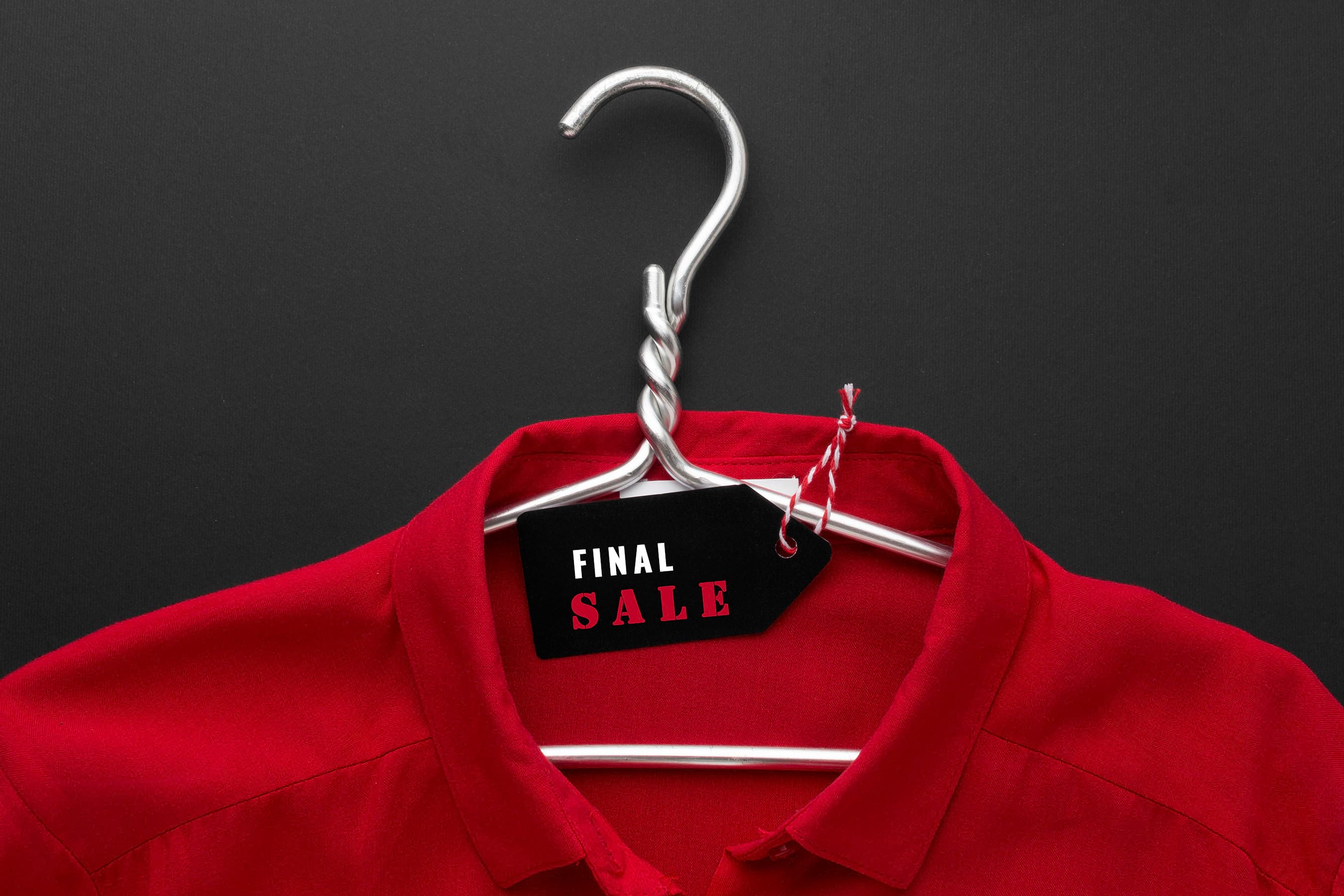 Rotes Shirt auf einem Drahtbügel mit dem Schild "Final Sale"